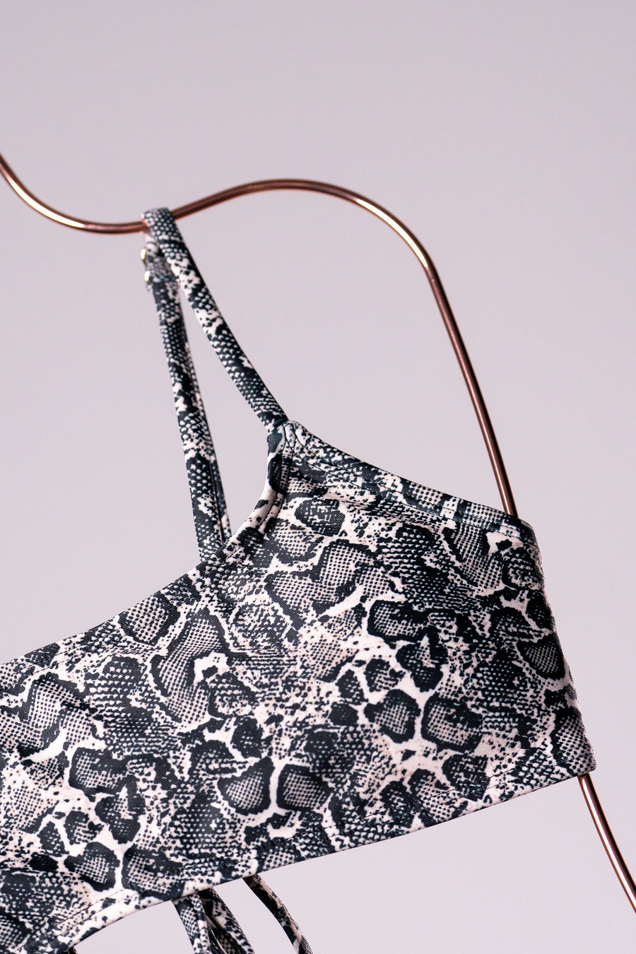 Snake-print bikini top on a copper hanger